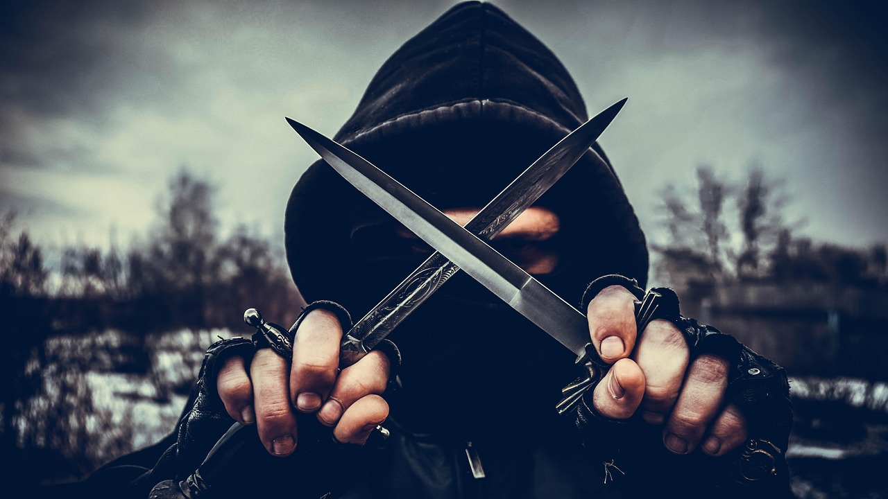 Un giocatore di un videogioco stealth, intento a pianificare una mossa strategica in un ambiente oscuro.