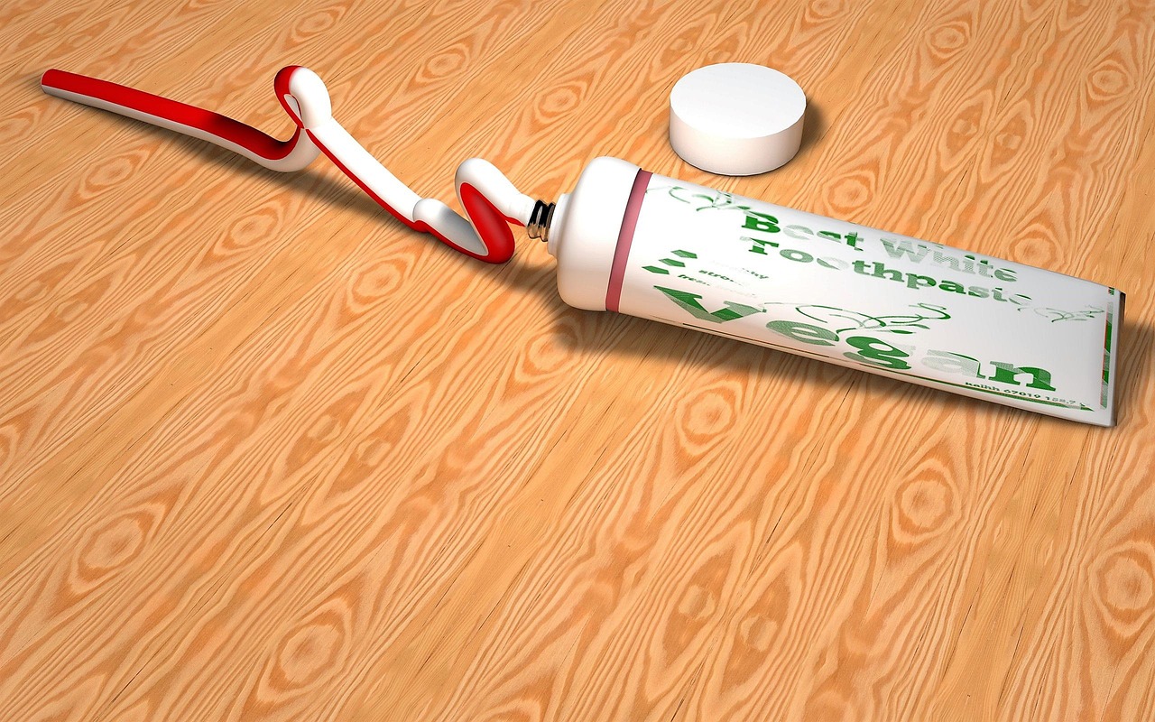 Dentifricio applicato su un graffio di legno per rimuovere imperfezioni.