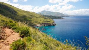 Panorama mozzafiato di un trekking in Sardegna, con montagne e mare cristallino sullo sfondo.