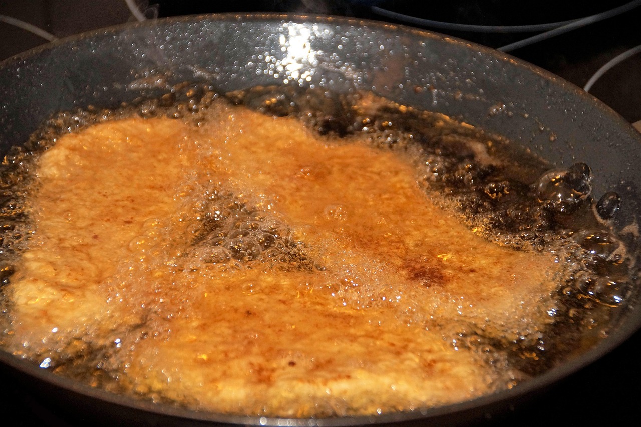 Donna che spruzza deodorante per ambienti in una cucina dopo aver fritto.