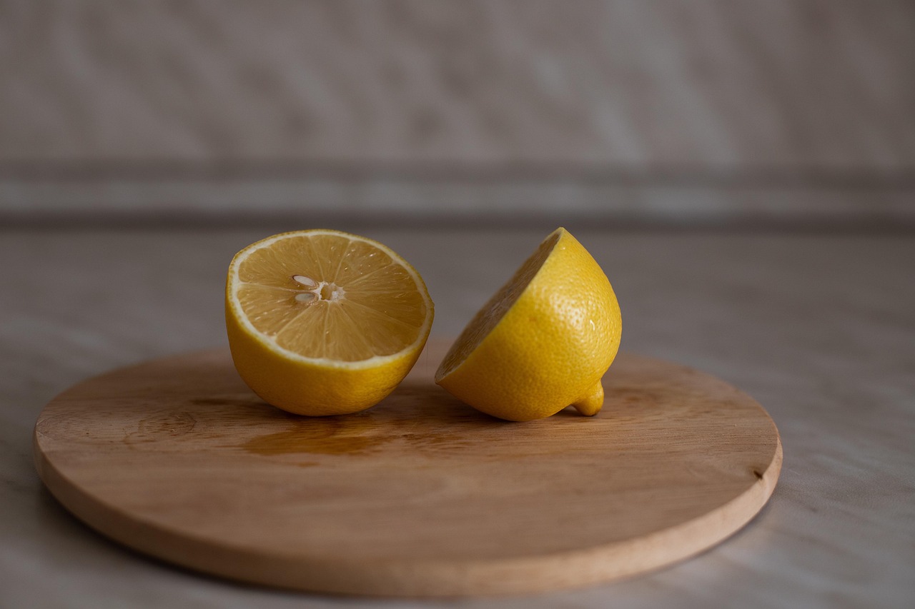 Limone tagliato su un tagliere di legno, pronto per disinfettare e sbiancare la superficie.