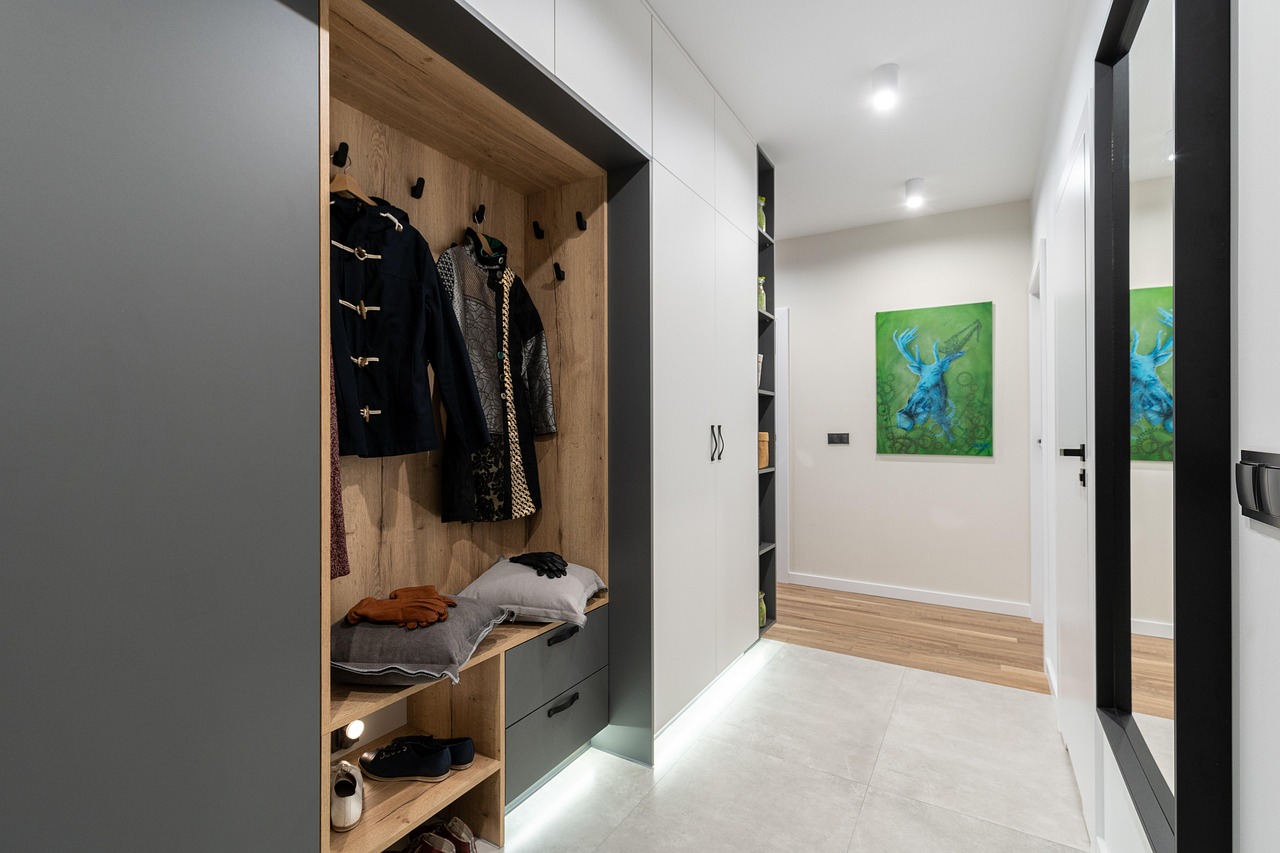 Ingresso di casa ben organizzato con soluzioni salvaspazio: mensole, appendiabiti e contenitori.